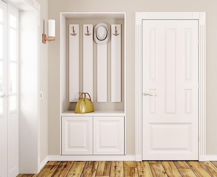 home entryway with white door, wood floors and coat racks