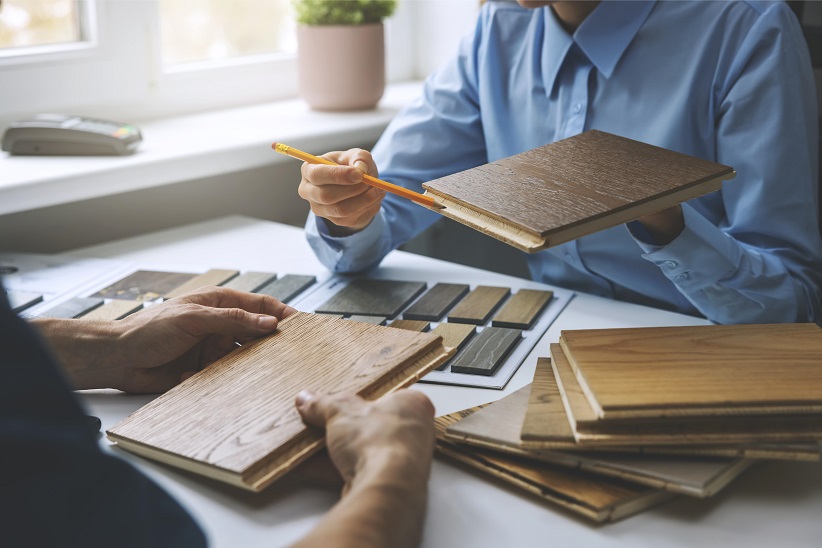 person showing wood flooring samples to someone