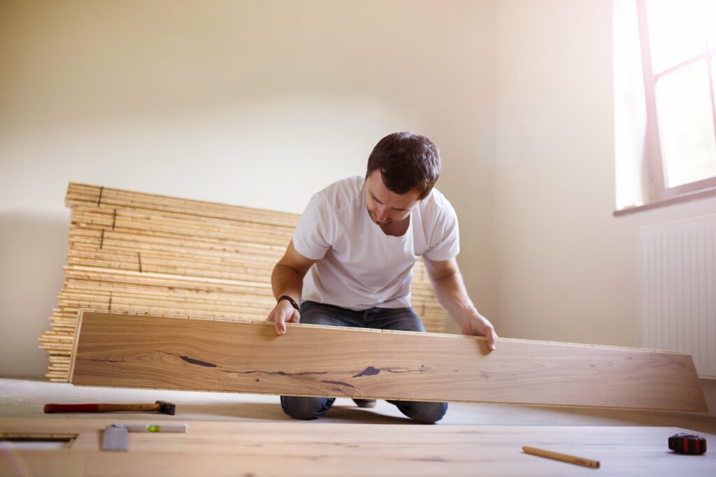 man installing wooden floor