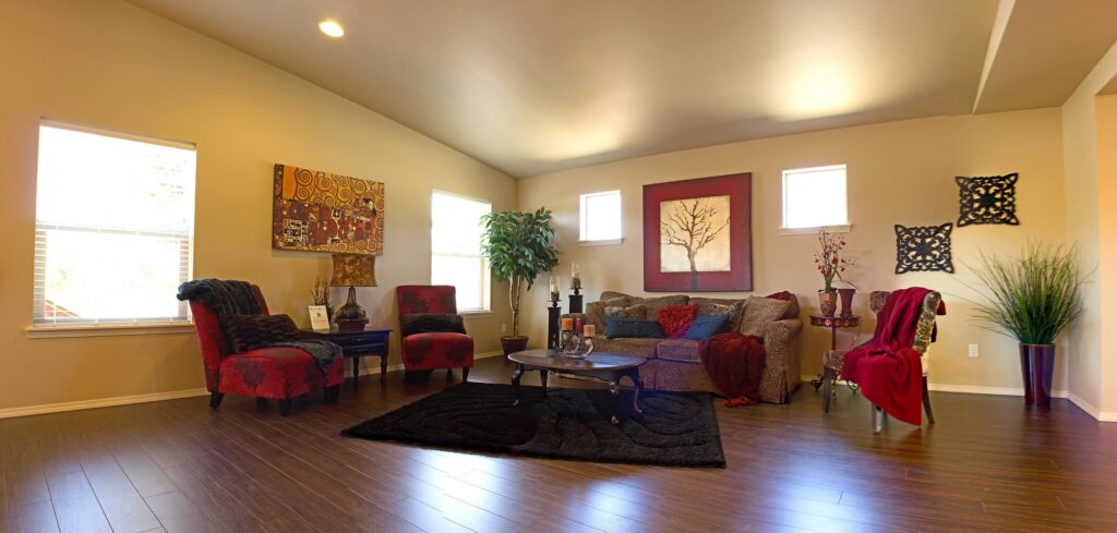 wood floors in living room with leopard courch and red accents