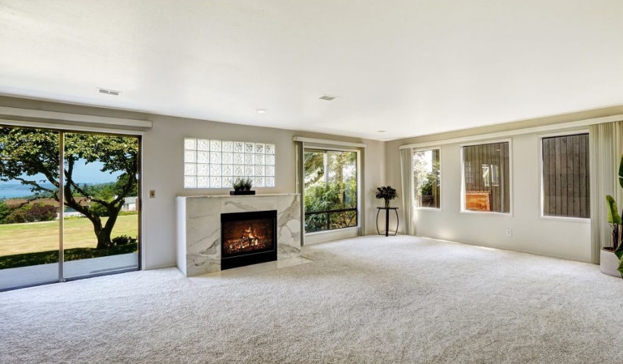 Room with fireplace and light carpet