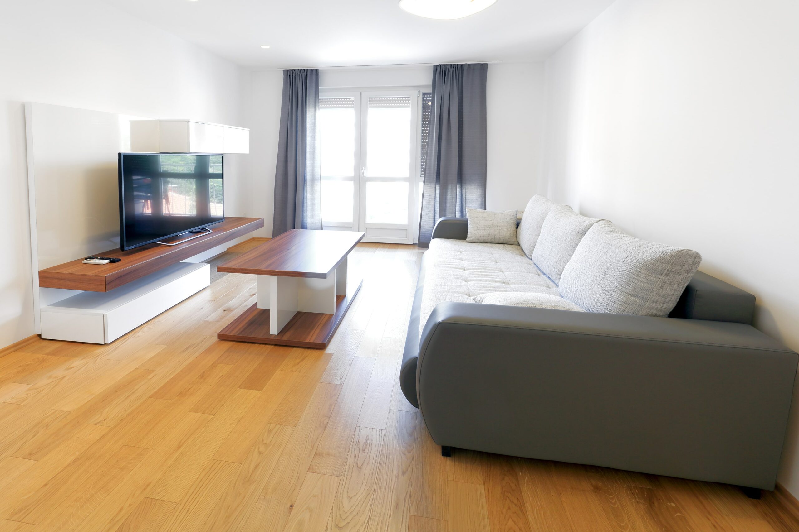 room with grey couch and light wood floors