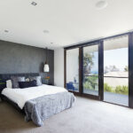 light carpet in bedroom with large windows