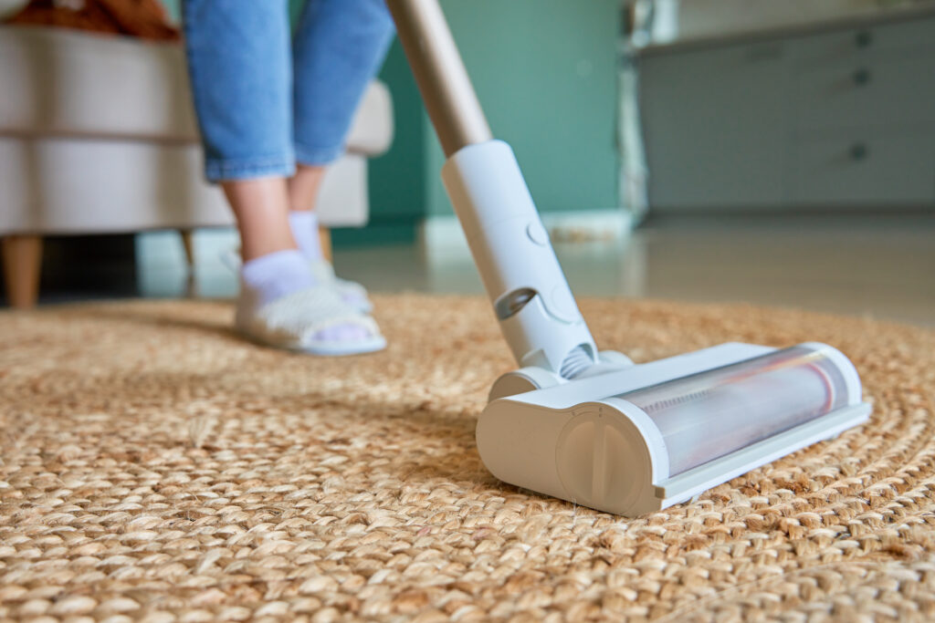 Close up of vacuum cleaner brush cleaning carpet on floor