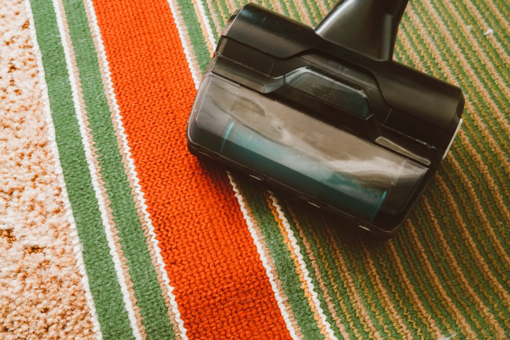 Using vacuum cleaner with brush at home from fur, closeup. Domestic animals in house. Garbage, pet hair concept